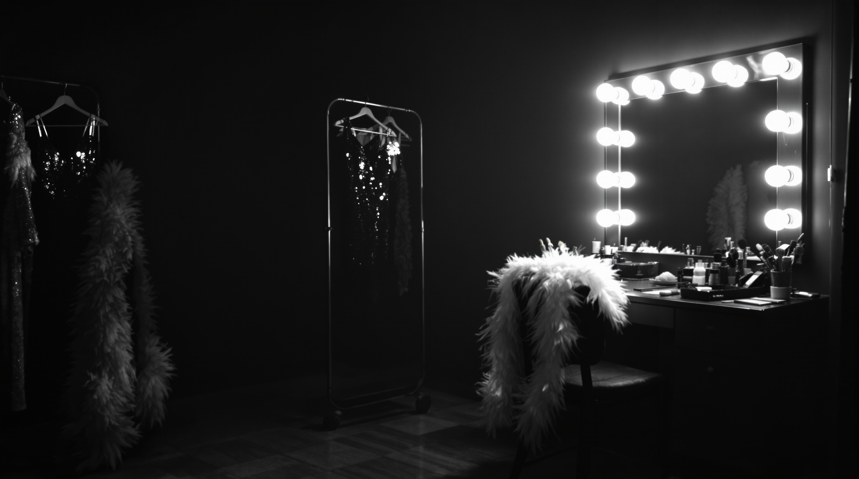 Empty dressing room with lighted mirror, hanging costumes and scattered makeup